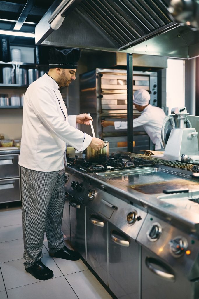 Male chef cooking in the kitchen at restaurant.